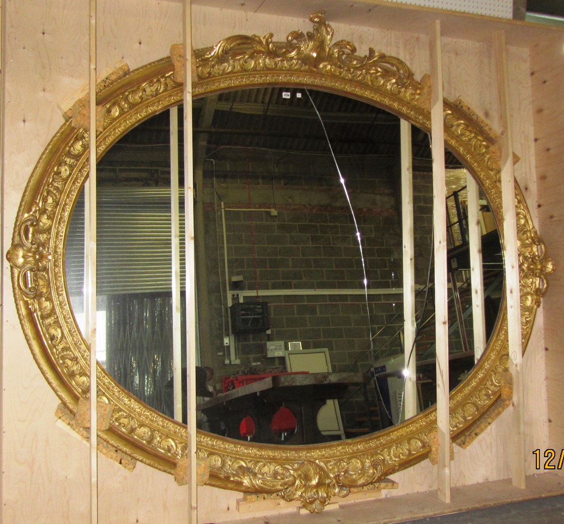 Appraisal: A massive th century oval gilt framed wall mirror with