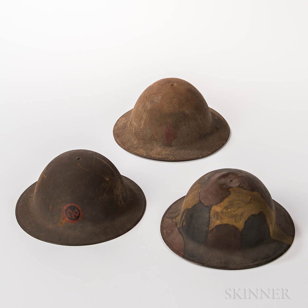 Appraisal: Three WWI Helmets Three WWI Helmets c a camouflage-painted helmet