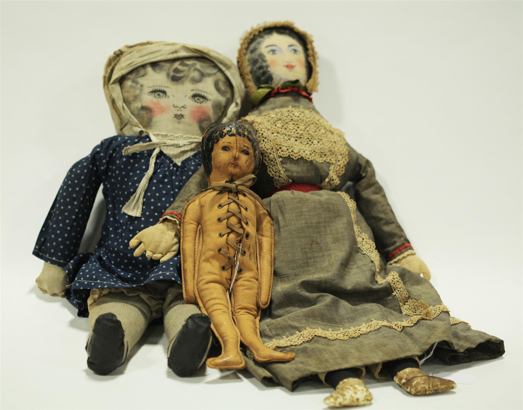 Appraisal: THREE DOLLS TWO CLOTH WITH PRINTED FACES ONE LEATHER American