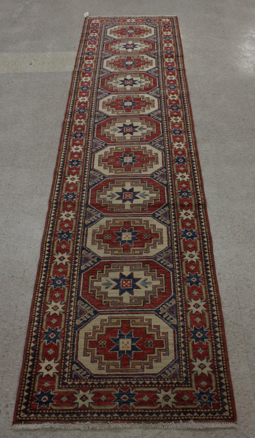 Appraisal: HAND KNOTTED PAKISTANI KAZAK RUNNER featuring a column of eleven