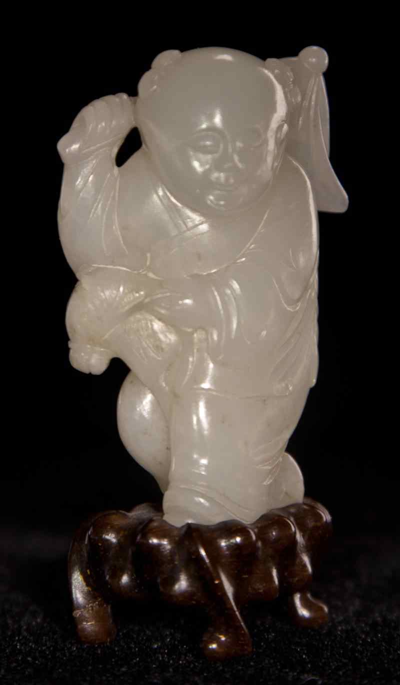 Appraisal: CHINESE WHITE JADE CARVING OF A BOY WITH PENNANT Qing