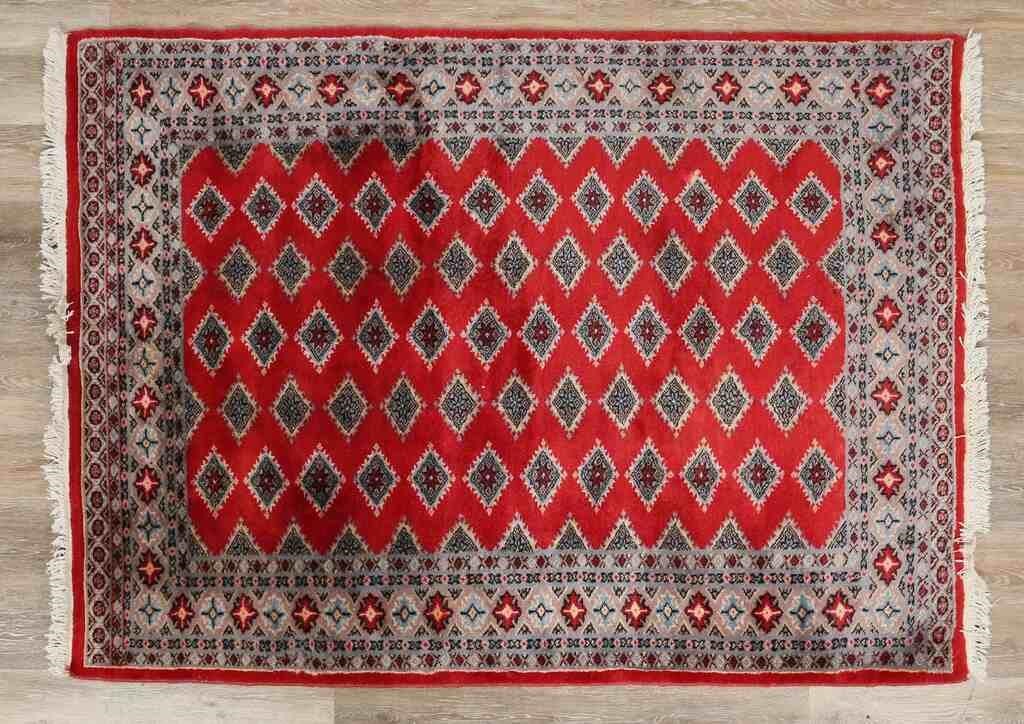 Appraisal: Persian rug Red field repeating diamond motifs Losses to fringe