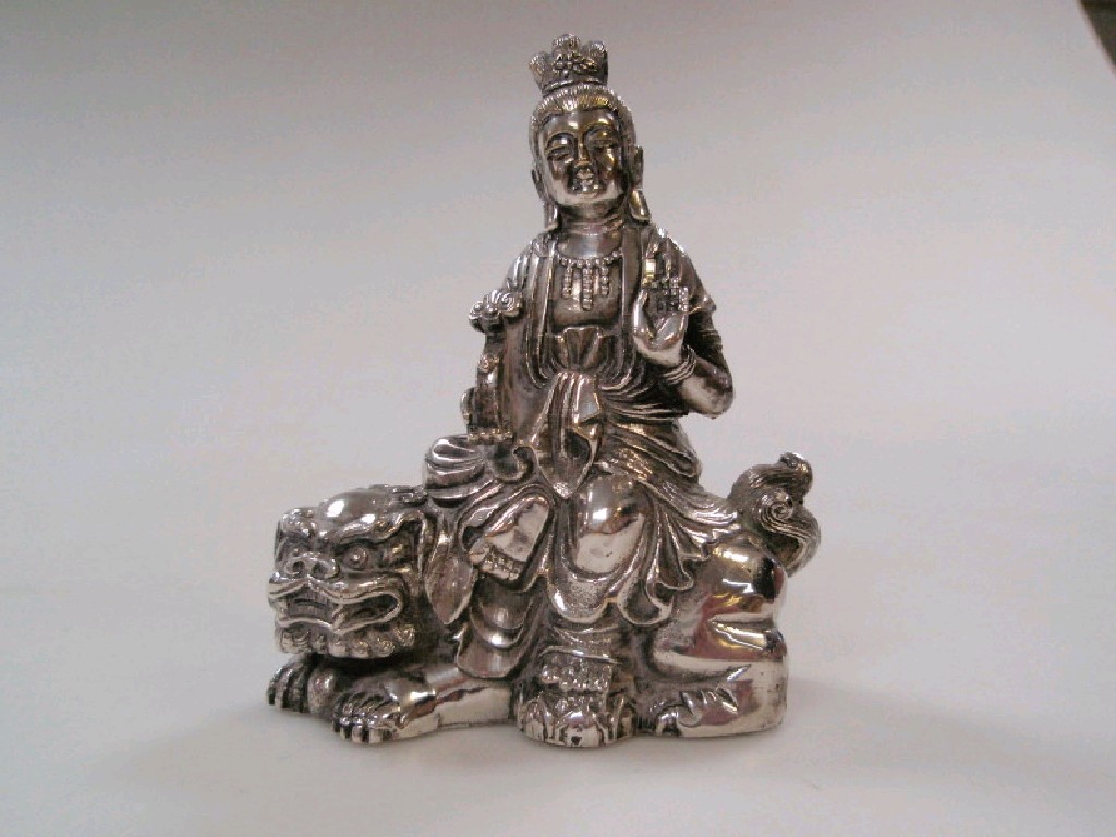 Appraisal: A heavy white metal figure of an oriental daiety astride