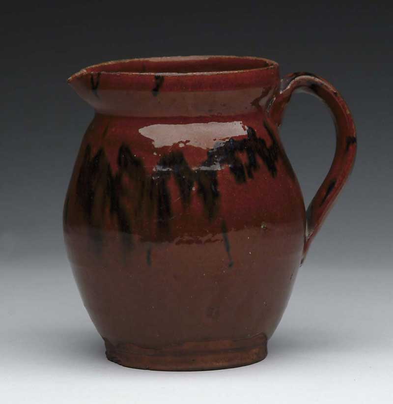 Appraisal: GLAZED REDWARE HANDLED PITCHER Ovoid shape with applied handle has