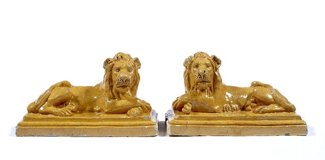 Appraisal: A pair of English pottery recumbent lions th Centuryeach with