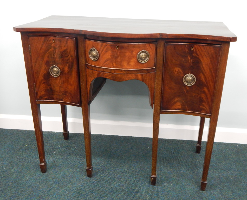 Appraisal: A small reproduction mahogany sideboard with a serpentine top above