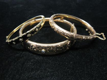 Appraisal: Assortment of three gold bangle bracelets all with diamonds