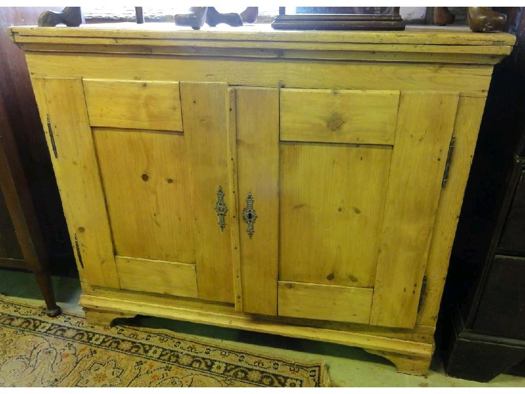 Appraisal: A th century stripped and waxed pine side cupboard enclosed