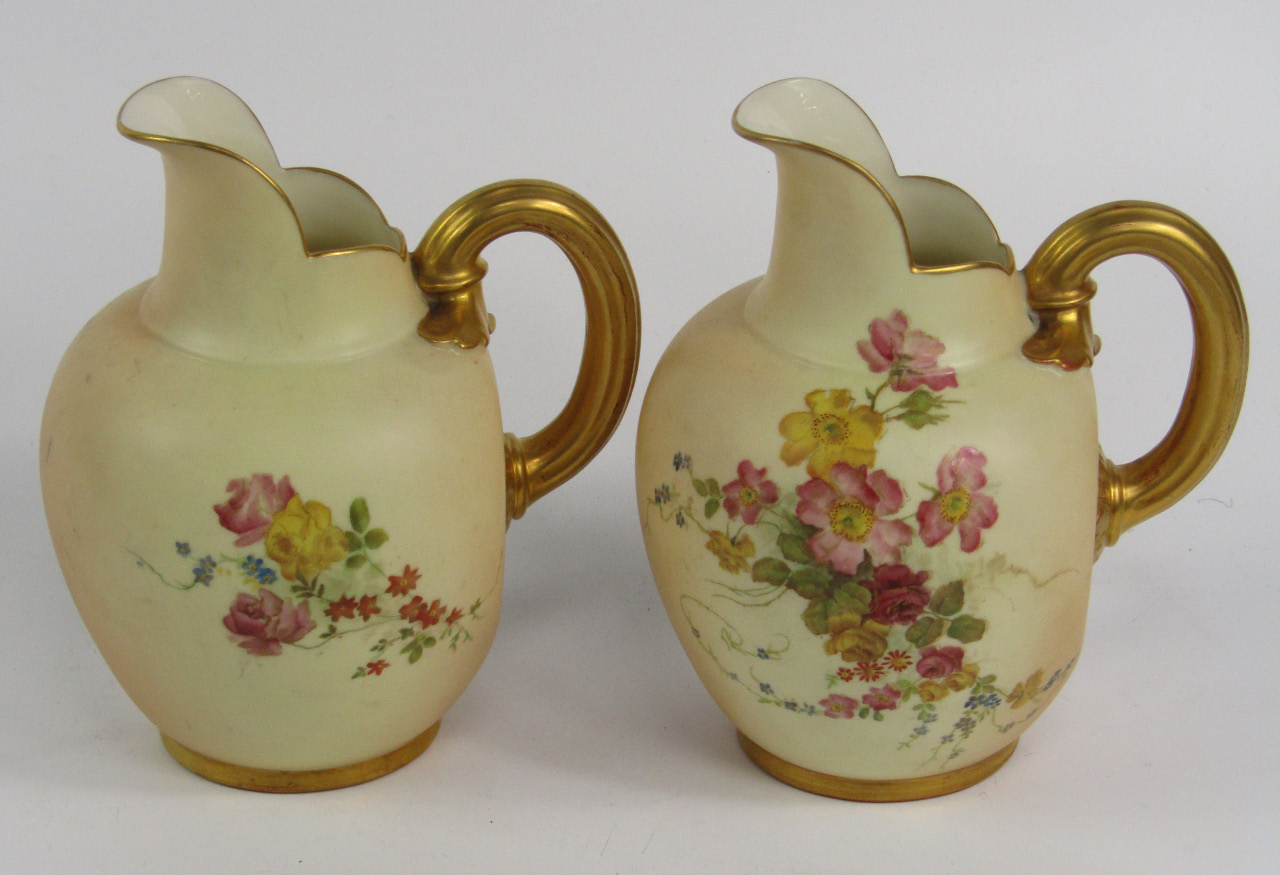 Appraisal: A pair of Royal Worcester blush porcelain jugs model painted