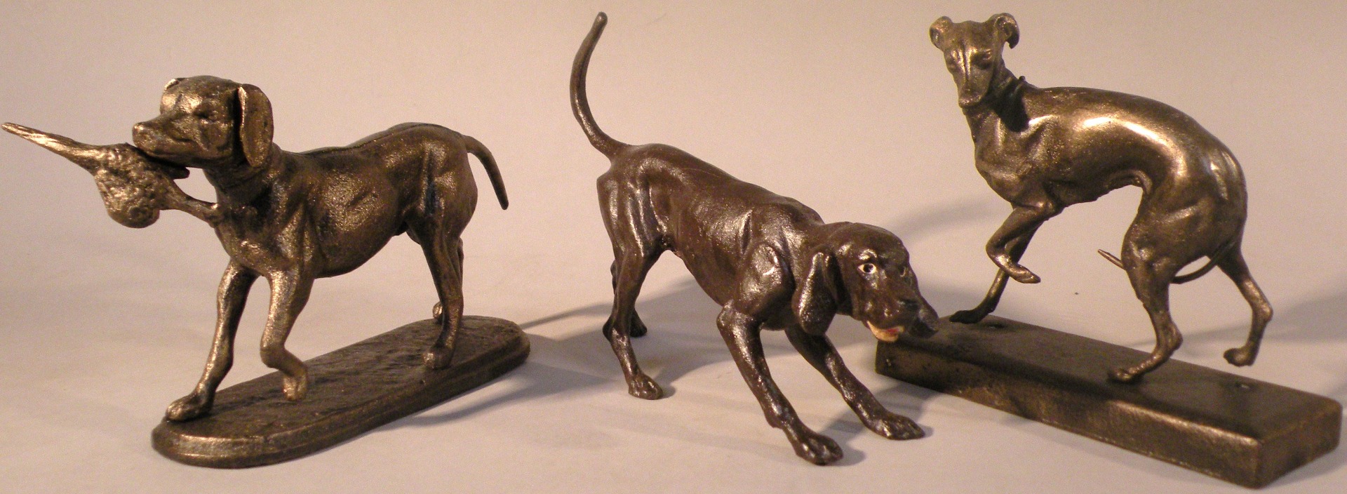 Appraisal: Three small cast dog figures cm high