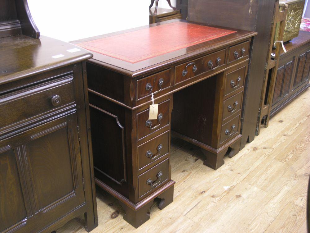 Appraisal: A reproduction mahogany kneehole desk with inset gilt tooled leather