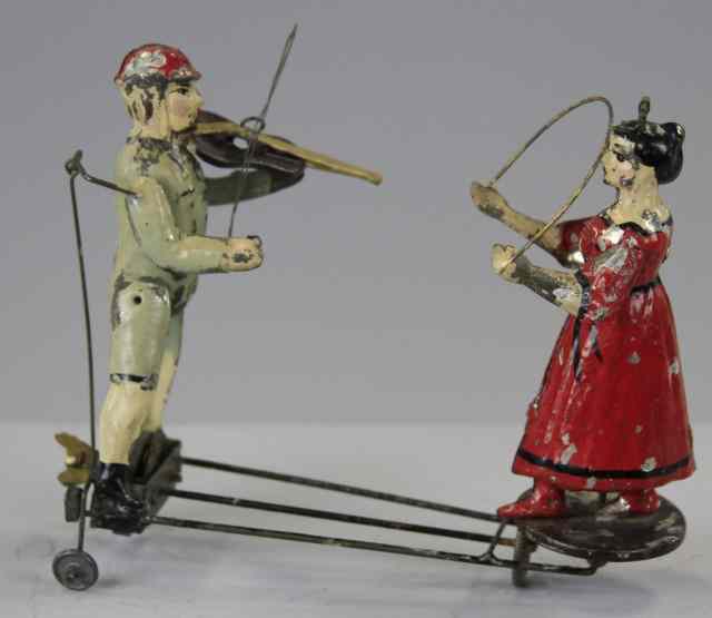 Appraisal: BOY MUSICIAN AND GIRL TWIRLING TOY Germany hand painted tin