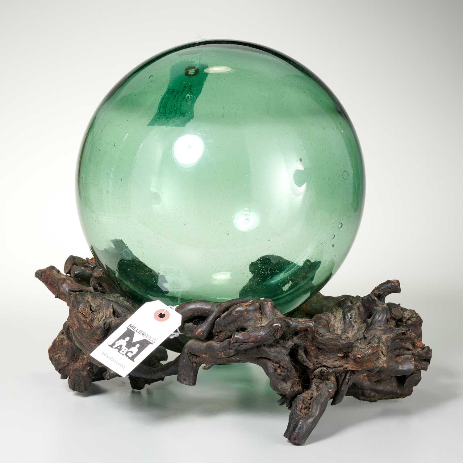 Appraisal: GREEN GLASS WITCH BALL ON TREE-ROOT STAND Approx dia ball