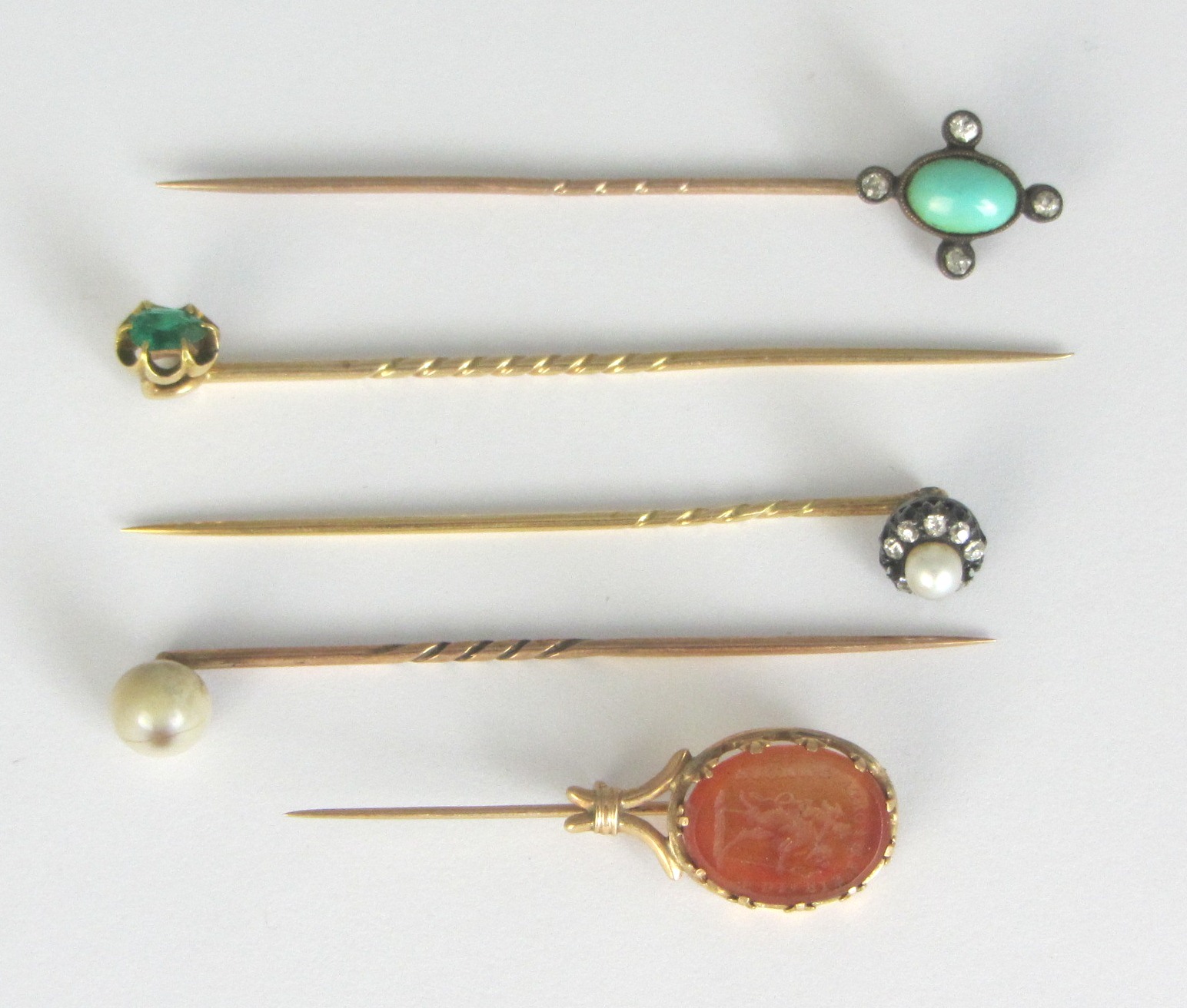 Appraisal: An emerald set single stone stick pin a turquoise and