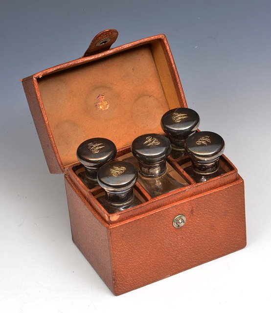 Appraisal: A LEATHER CASED SET OF FIVE SILVER TOPPED GLASS BOTTLES