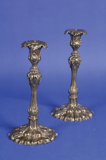 Appraisal: A PAIR OF EDWARDIAN CANDLESTICKS with waisted cylindrical stems applied