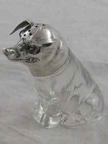 Appraisal: A silver mounted pepper designed as a seated pig bearing