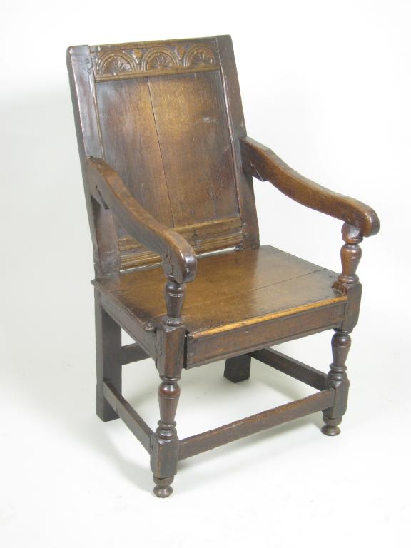 Appraisal: An antique oak Elbow Chair with carved top rail shaped