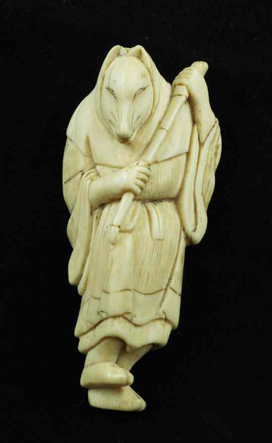 Appraisal: An Edo period ivory netsuke carved as a fox-woman holding