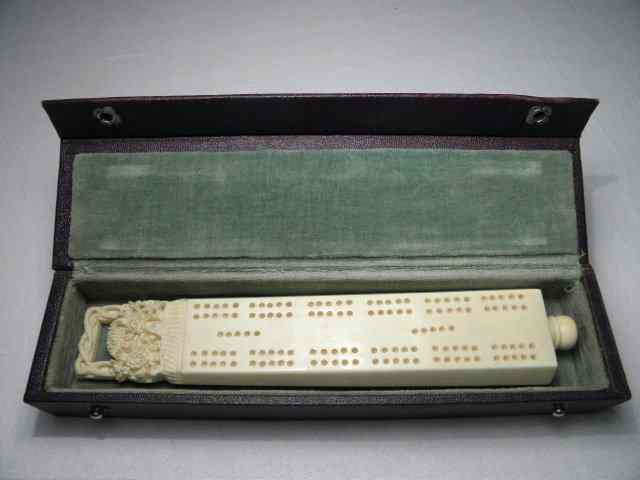 Appraisal: Cased carved ivory cribbage board and pieces Includes the board