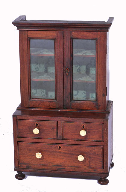 Appraisal: A VICTORIAN MINIATURE MAHOGANY DRESSER with glazed doors above enclosing