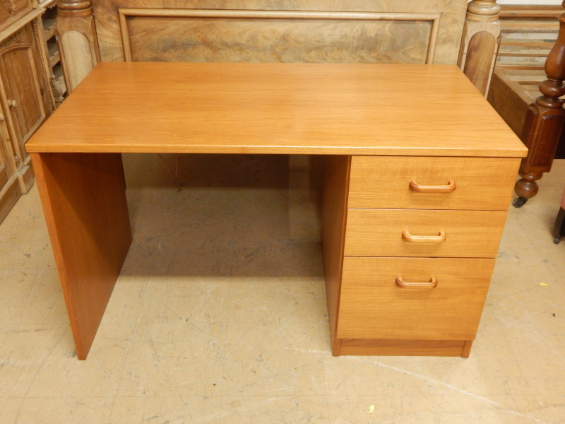 Appraisal: A retro style teak kneehole desk with three drawers on