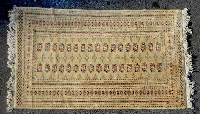 Appraisal: AN ORIENTAL BOKHARA STYLE PALE SAGE GROUND RUG decorated two