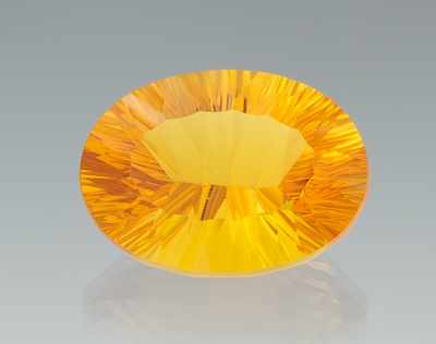 Appraisal: An Unmounted Orange Color Citrine Oval concave cut citrine weighing