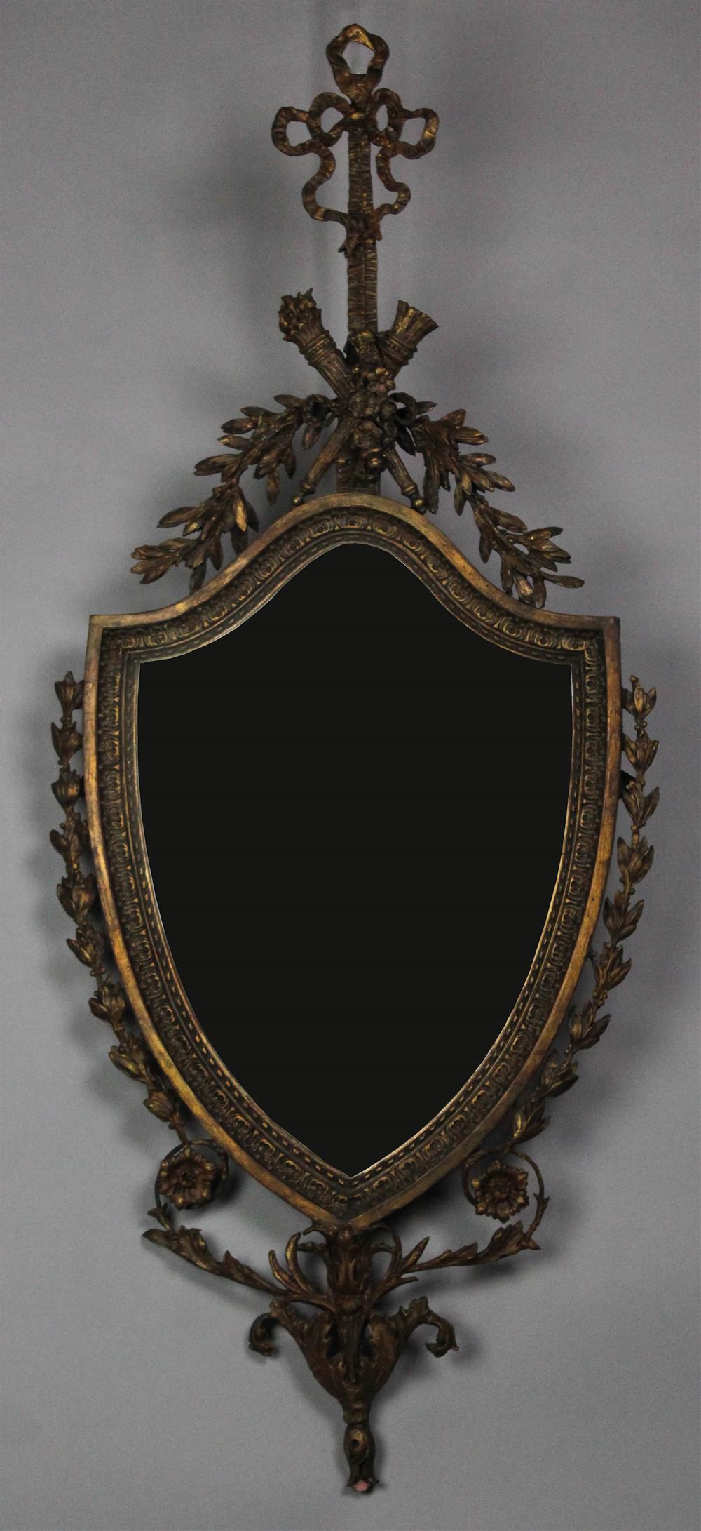 Appraisal: GEORGE III STYLE GILTWOOD AND COMPOSITION SHIELD-FORM MIRROR early th