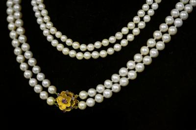 Appraisal: A cultured pearl two-row necklace with gem set flowerhead clasp