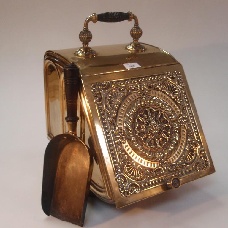 Appraisal: A Victorian brass coal scuttle with embossed cover ebonised handle