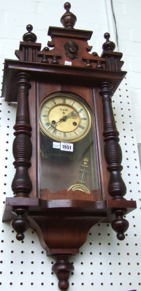 Appraisal: A mahogany cased wall clock the urn finial cornice over