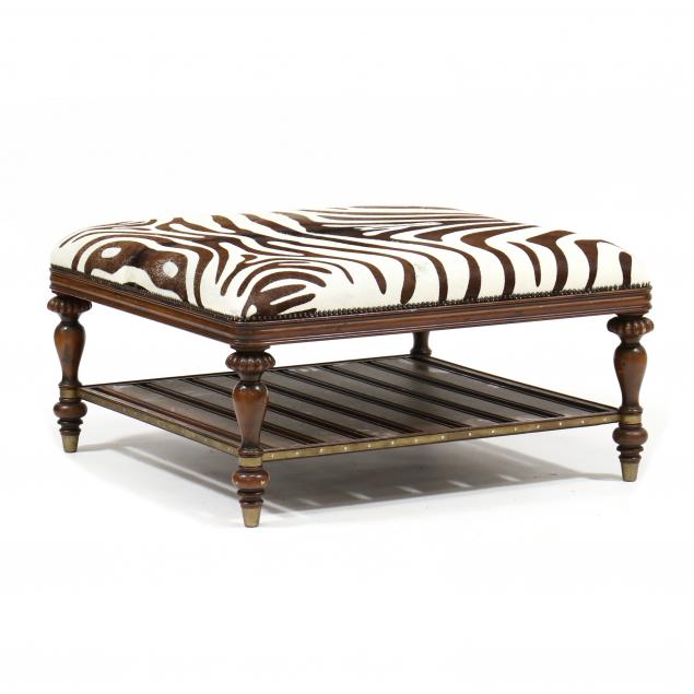 Appraisal: PRINTED HIDE AND MAHOGANY OTTOMAN COCKTAIL TABLE Contemporary brown white