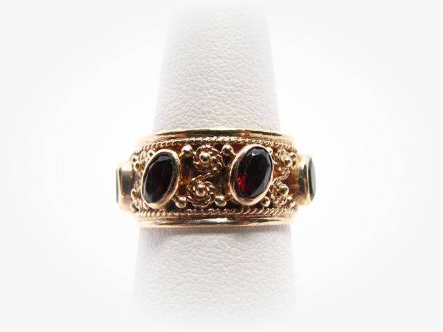 Appraisal: k yellow wide gold band with seven oval garnets the