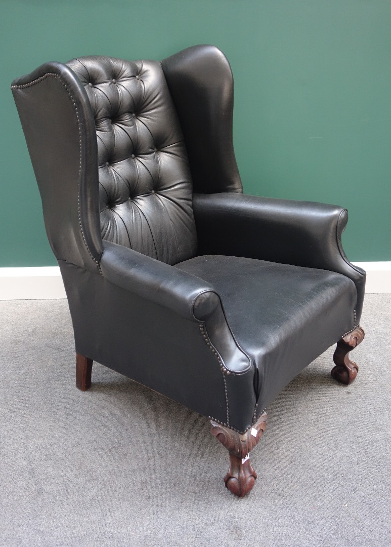 Appraisal: An th century style black leather upholstered wing back chair