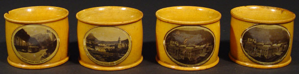 Appraisal: Set of four Mauchlin napkin rings printed with scenes of