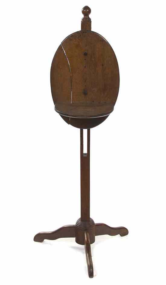 Appraisal: An American Maple Candlestand the oval backplate set with a