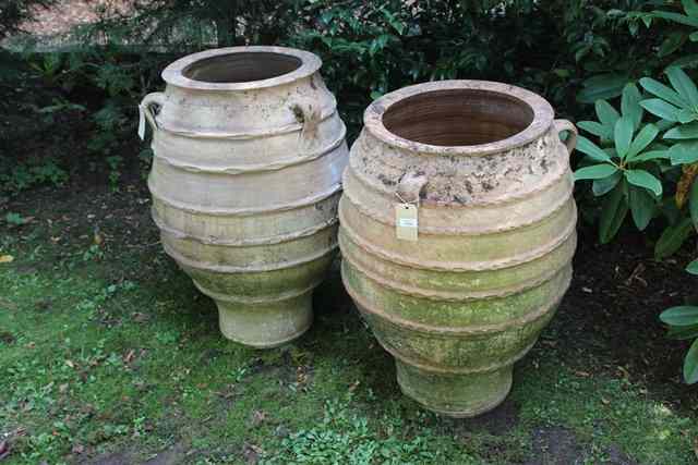 Appraisal: TWO SIMILAR TERRACOTTA OVOID PLANTERS with ribbed decoration and three