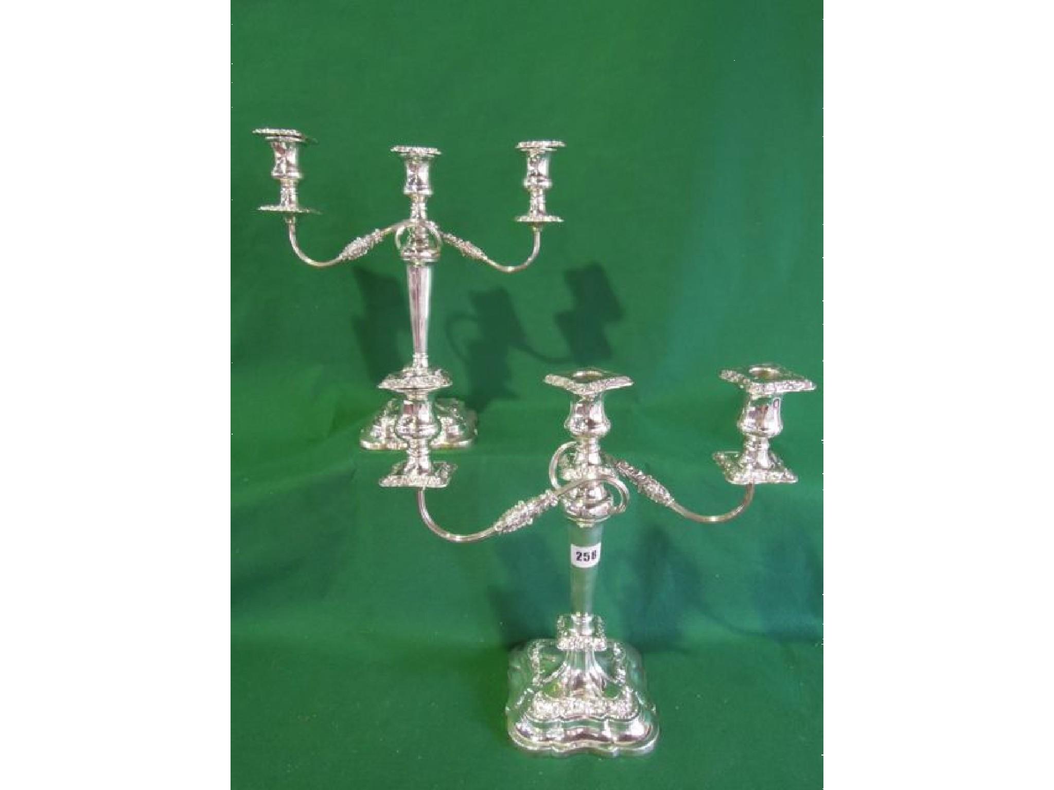 Appraisal: A pair of silver three branch candelabra on stepped bases