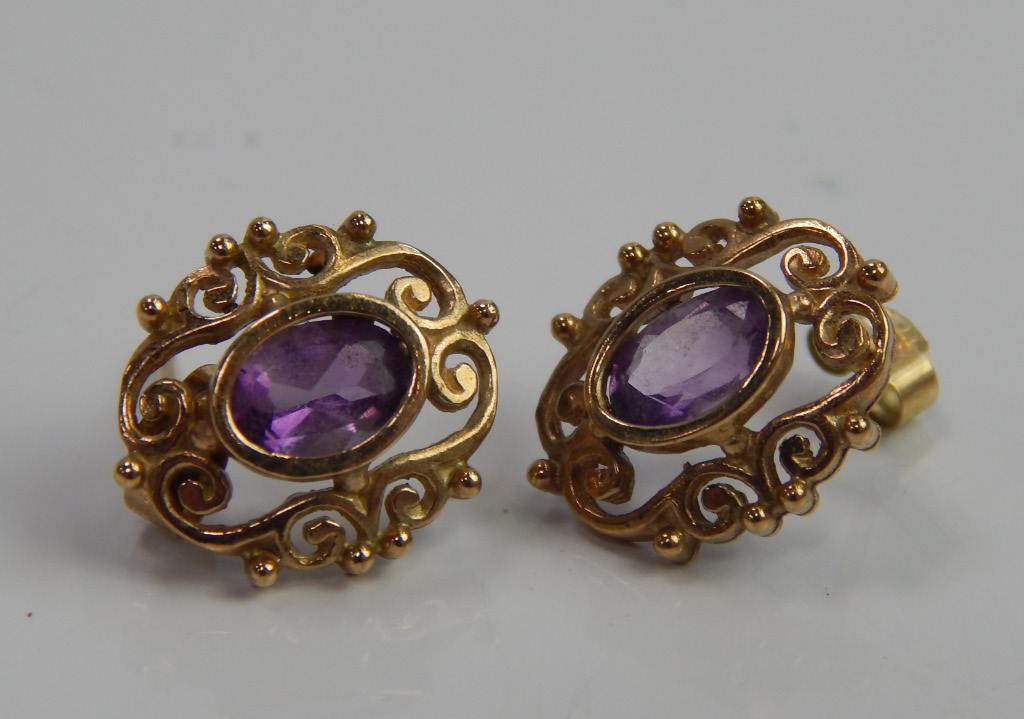 Appraisal: A pair of amethyst set earrings in floral scroll form