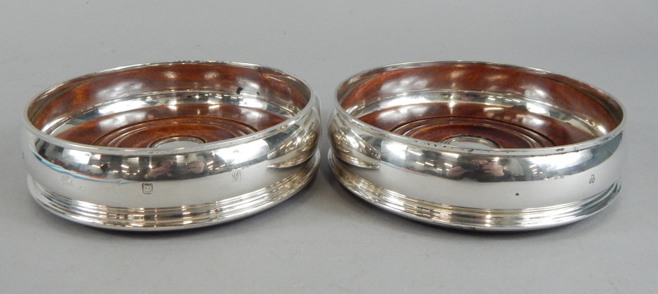 Appraisal: A pair of modern silver and mahogany wine coasters each