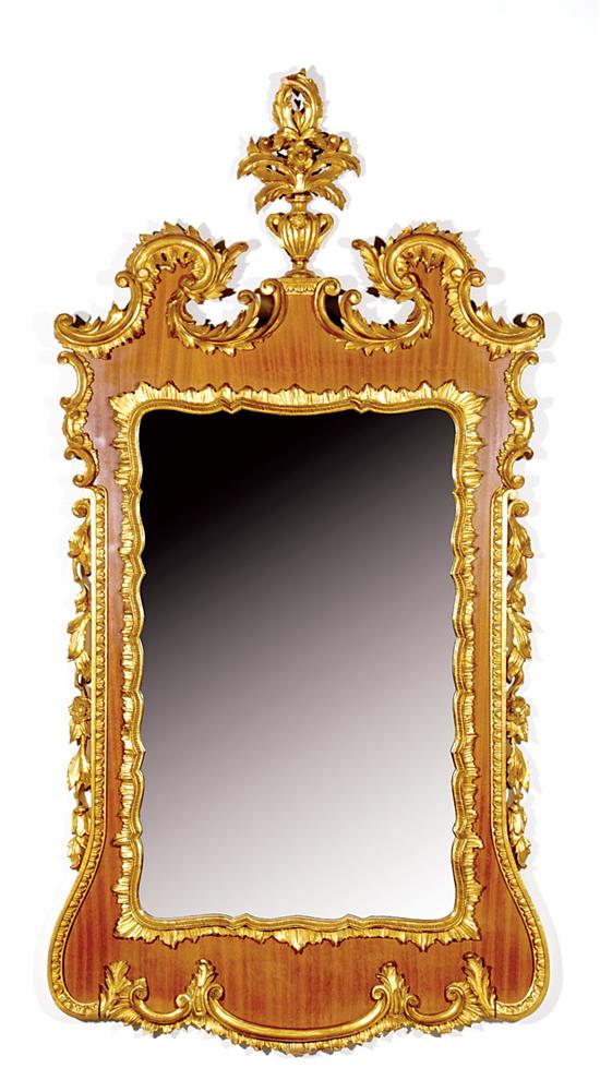 Appraisal: Carved giltwood and mahogany looking glass shaped and molded frame