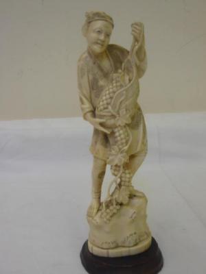 Appraisal: A CARVED IVORY OKIMONO depicting a farmer standing holding a