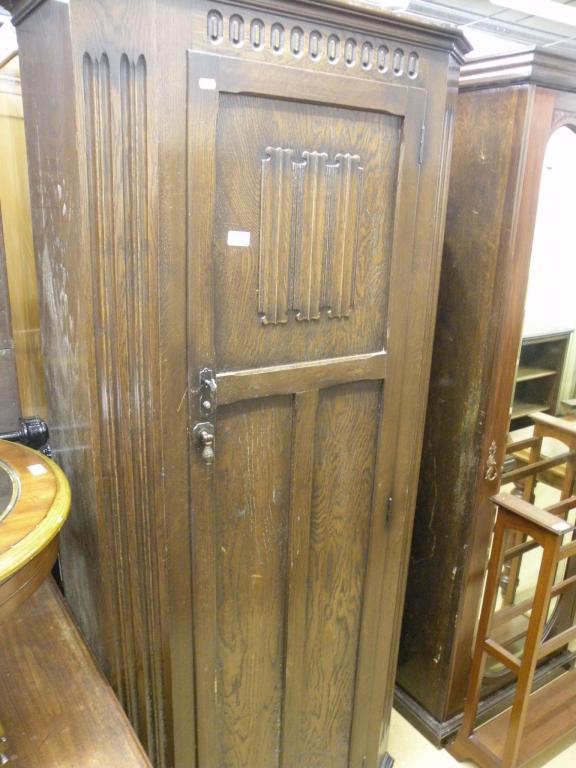 Appraisal: An oak single door wardrobe carved with linen folds