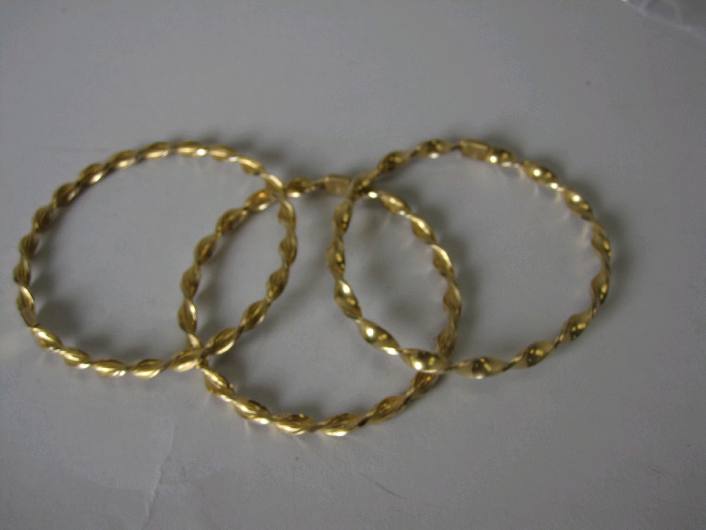 Appraisal: Three twisted Gold Bangles