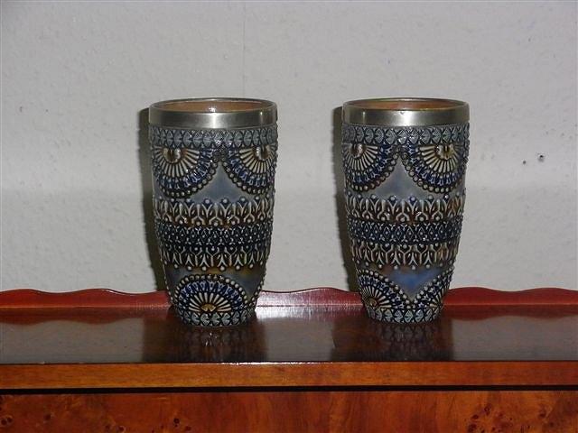 Appraisal: A PAIR OF DOULTON LAMBETH ELIZA MARTIN BEAKERS with silver