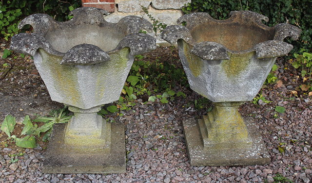 Appraisal: A PAIR OF CAST COMPOSITION STONE OCTAGONAL URNS with scrolling