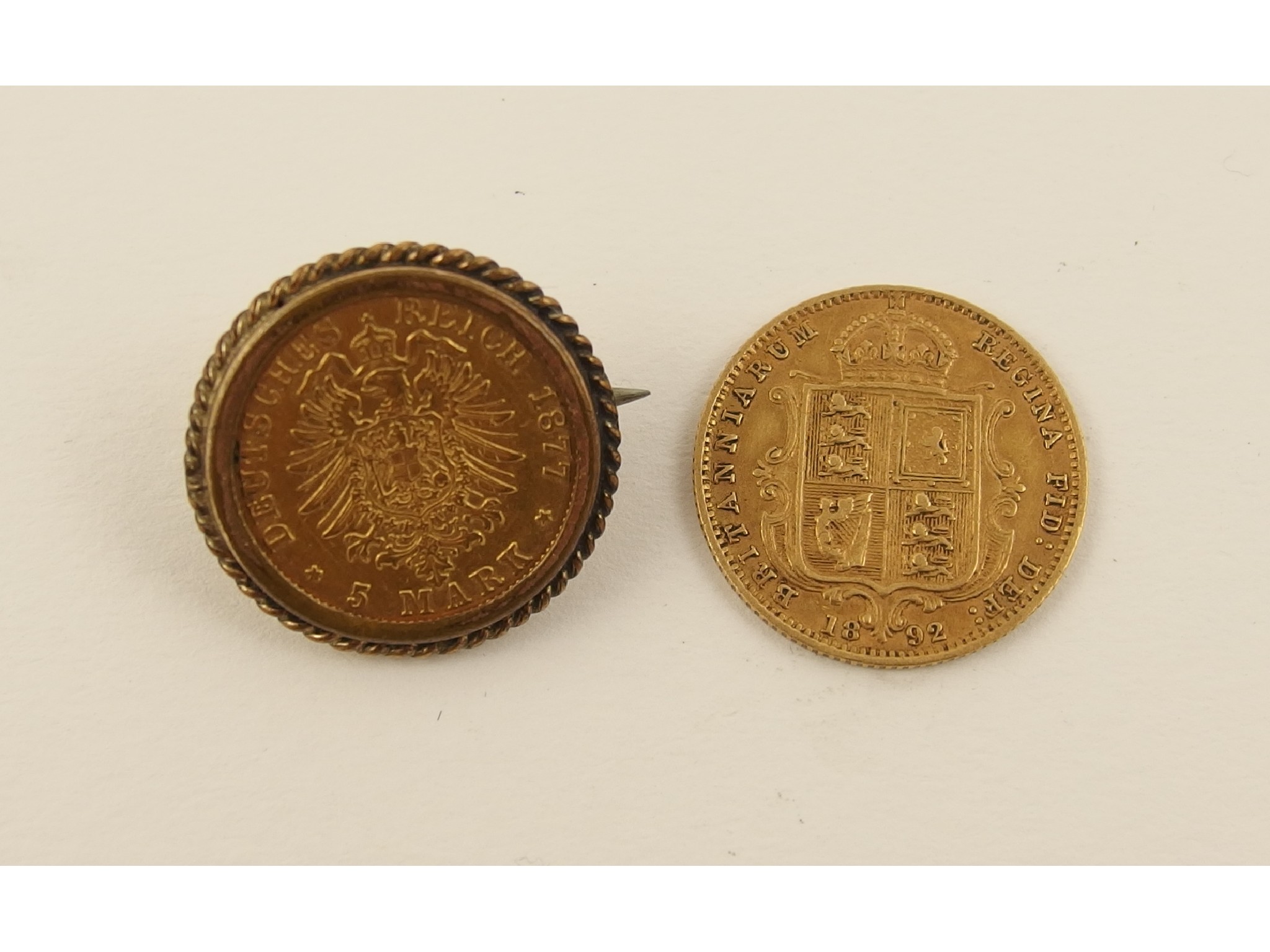 Appraisal: An gold half sovereign together with an Mark coin mounted