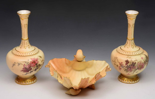 Appraisal: A pair of Royal Worcester blush ivory vasespattern painted with