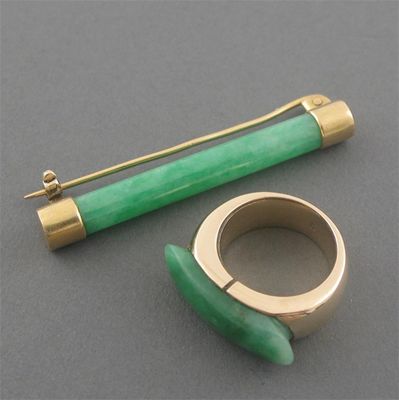 Appraisal: A jade mounted gold saddle ring and a jade cylinder